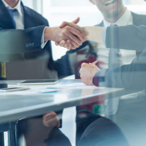 Two office workers shaking hands to promote Greenfield Risk Solutions Insurance Brokers - Financial Lines - Professional Indemnity Insurance