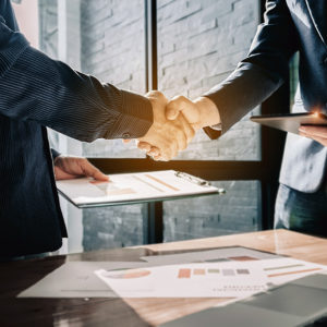 Two office workers shaking hands to promote Greenfield Risk Solutions Insurance Brokers - Financial Lines