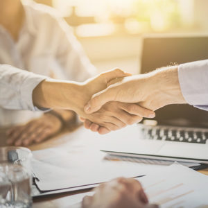 Two office workers shaking hands to promote Greenfield Risk Solutions Insurance Brokers - Financial Lines - Employment Practices Liability Insurance
