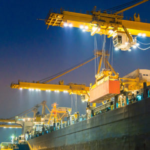 Cranes unloading shipping crates to promote Greenfield Risk Solutions Insurance Brokers - High Risk and Complex Liability Insurance - Overseas Exposure