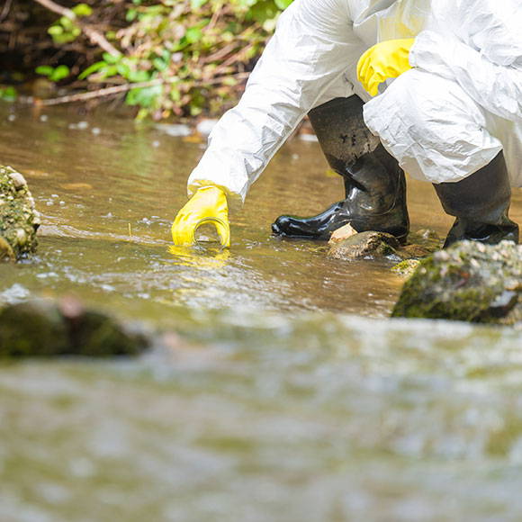 Environmental specialist taking water sample from a local river to promote Greenfield Risk Solutions Insurance Brokers - High Risk Complex Liability - Liability