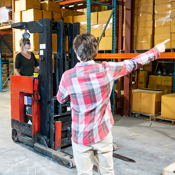 Employee directing a forklift truck driver to promote Greenfield Risk Solutions Insurance Brokers - Driver Training Insurance