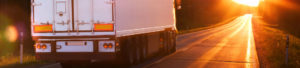 HGV on the road at sunset to promote Greenfield Risk Solutions Insurance Brokers Training Driver Scheme