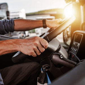 Man holding steering wheel to promote Greenfield Risk Solutions Insurance Brokers Training Driver Scheme