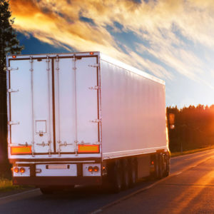 HGV on the road at sunset to promote Greenfield Risk Solutions Insurance Brokers Training Driver Scheme